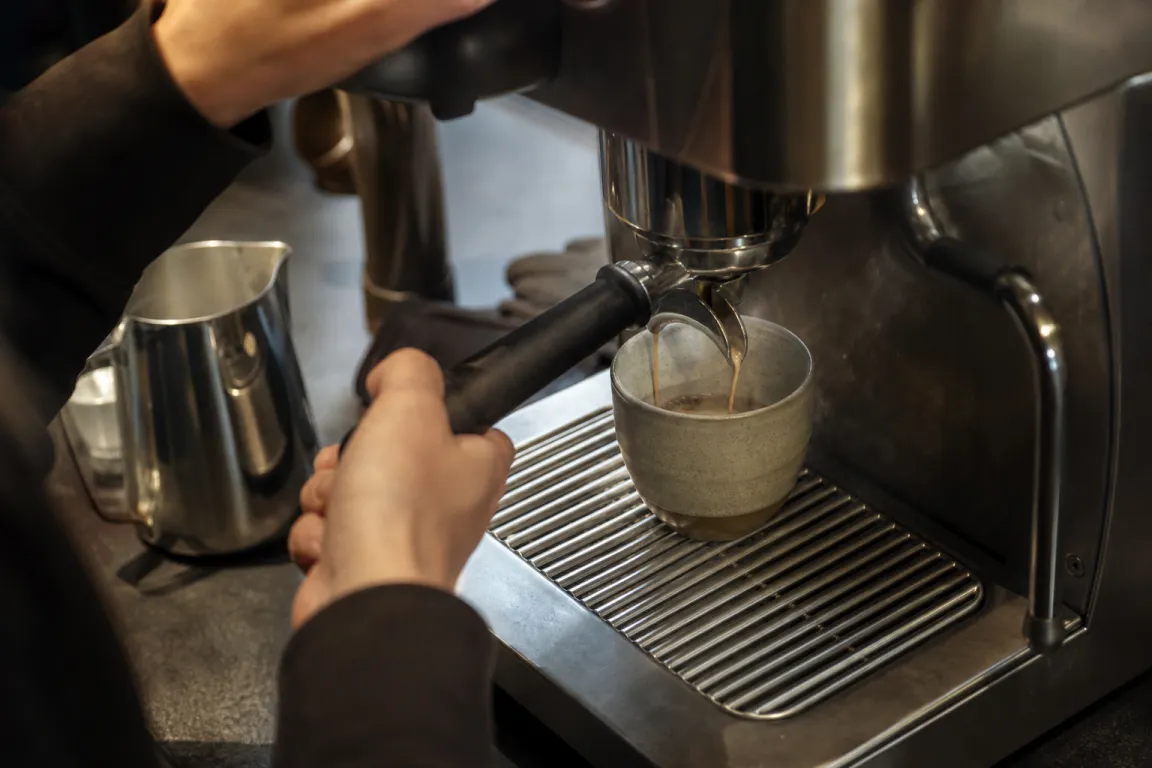 Mjölk hälls i en espressokopp och formar ett enkelt hjärtmönster