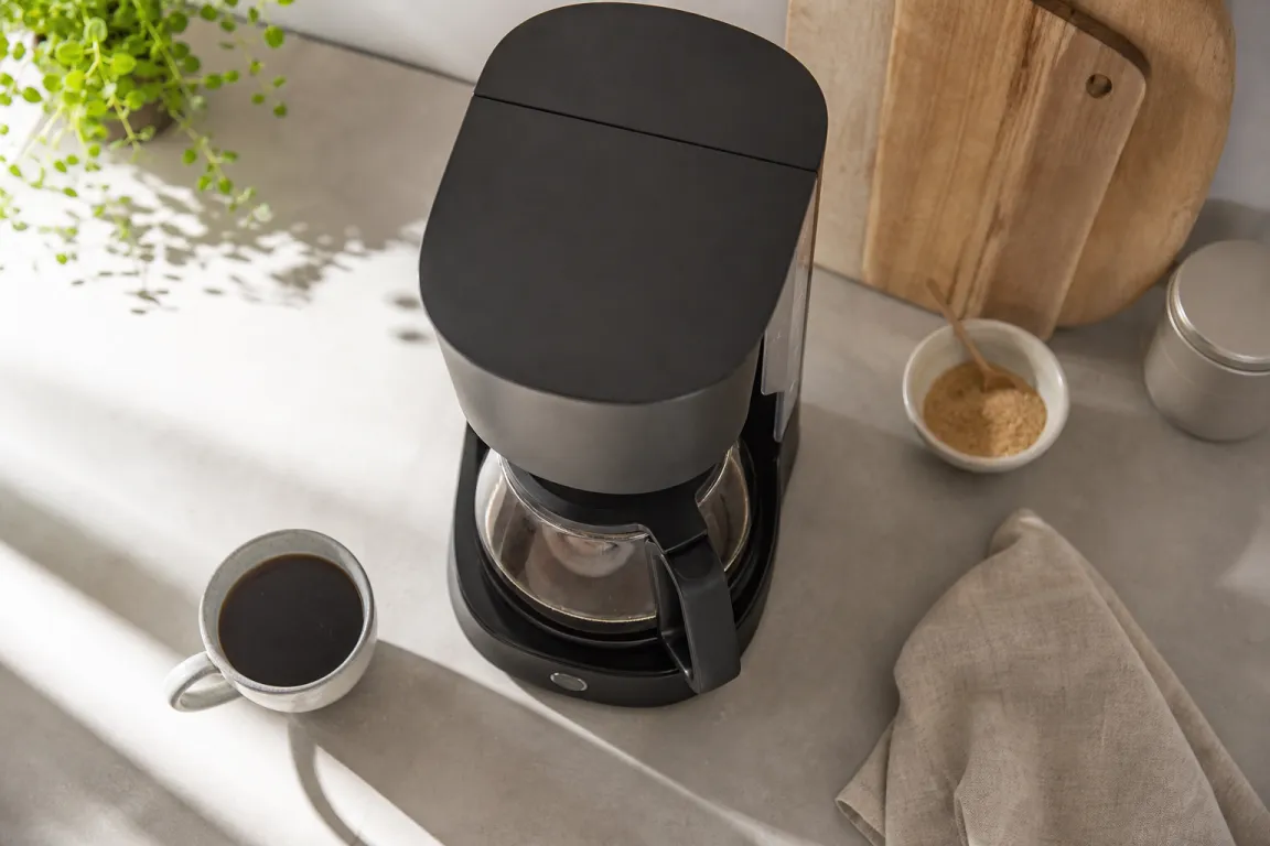 Olika typer av kaffemaskiner uppställda bredvid varandra på ett köksbänk