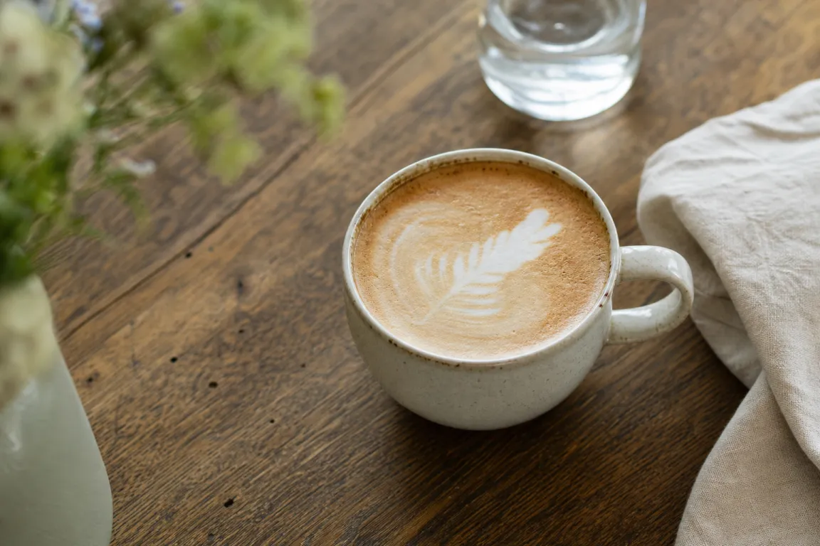 Caffè latte i högt glas med tunt lager mjölkskum
